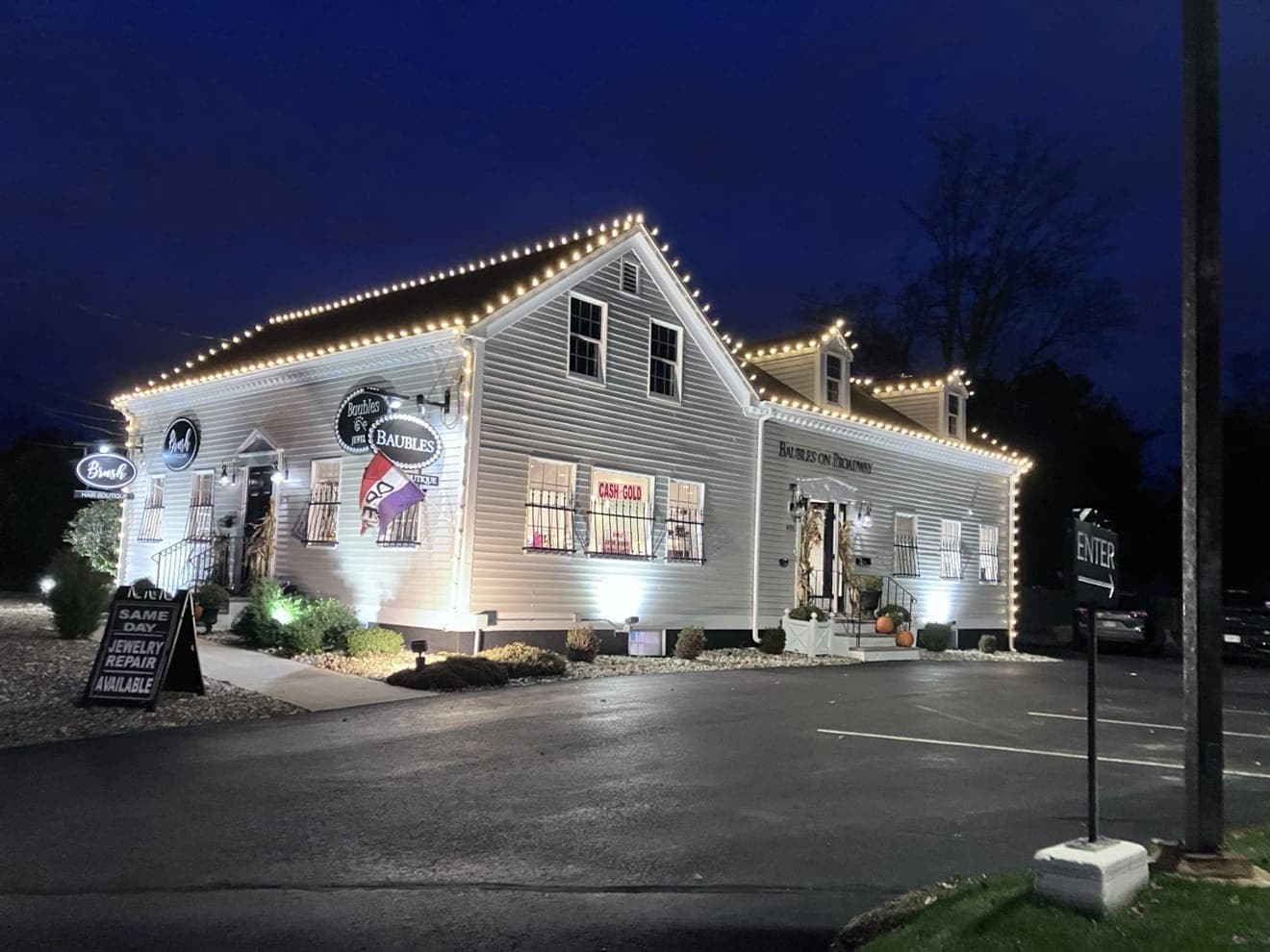 Jewelry store with warm-white roofline and dormer lights at night